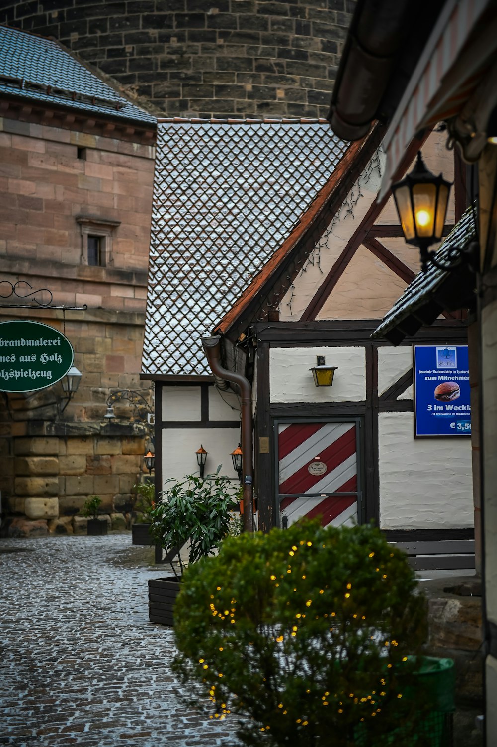 a cobblestone street with a brick building in the background