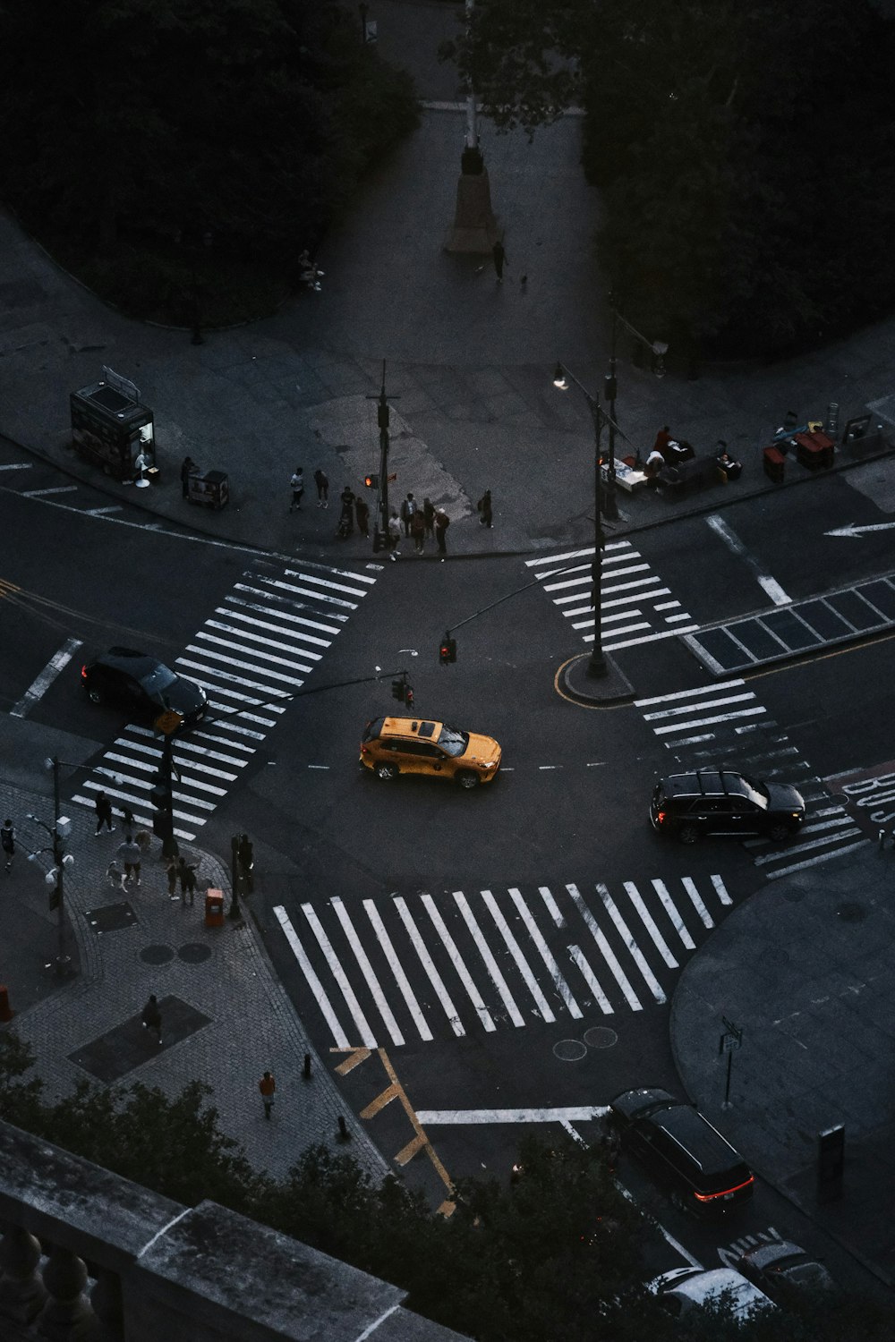 a yellow taxi cab driving down a street next to a traffic light