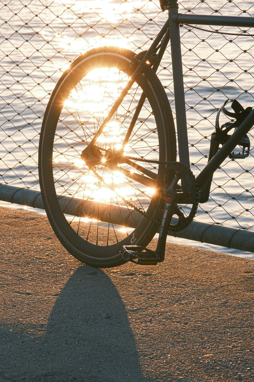 a bike leaning against a fence near the water