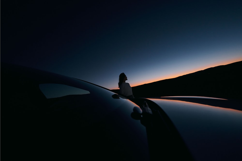 a person standing on the hood of a car