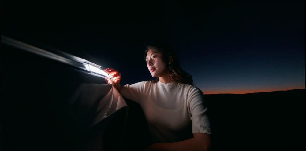 uma mulher está segurando uma luz em sua mão