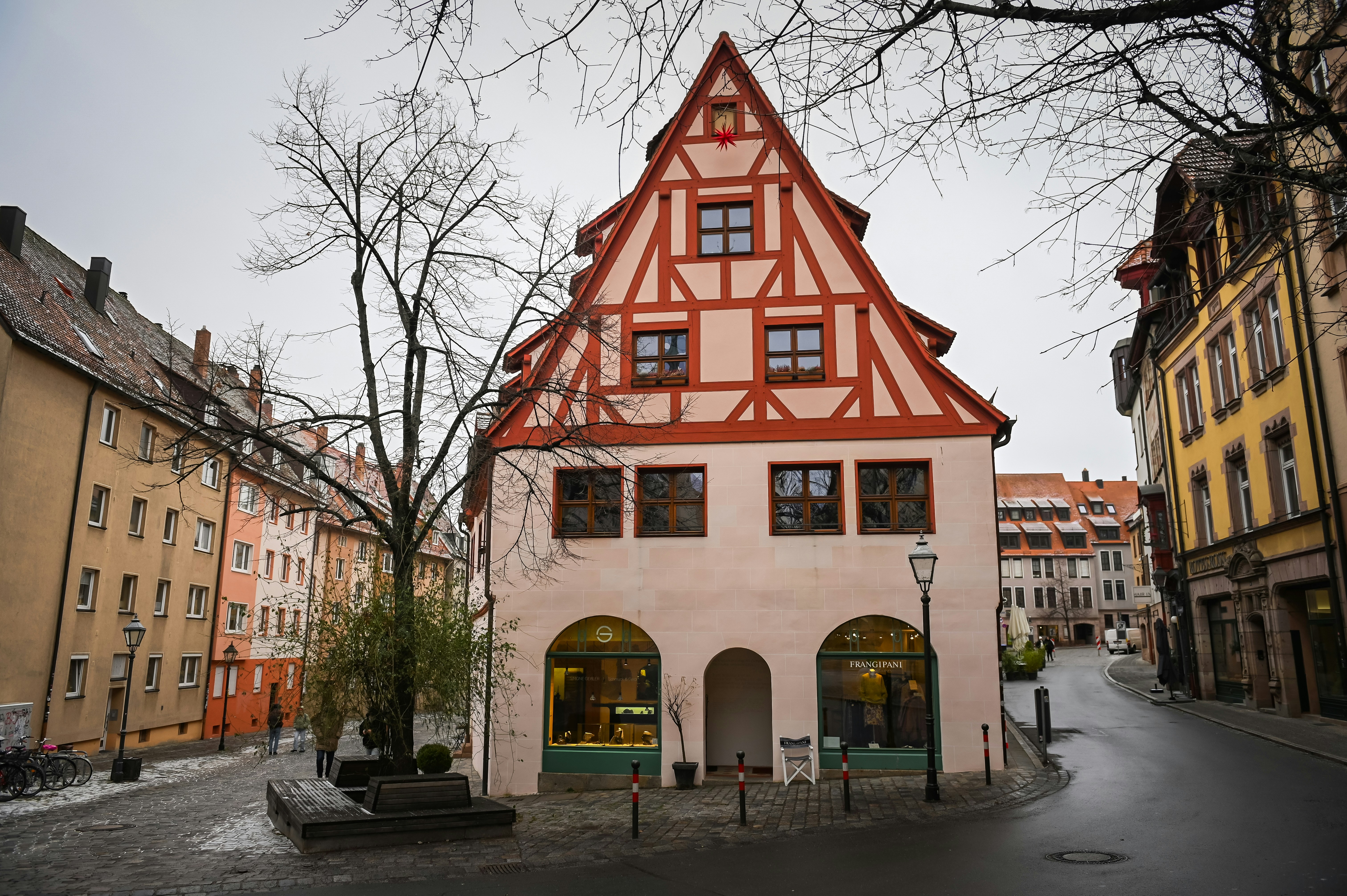 a building with a red and white roof next to a street