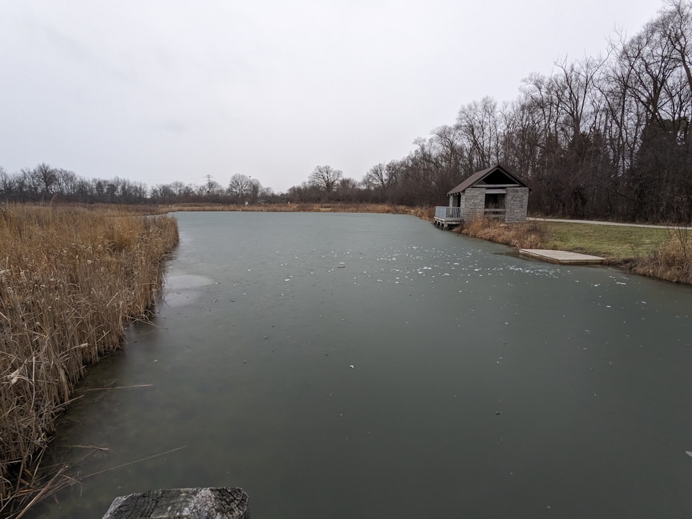 a body of water with a house in the background