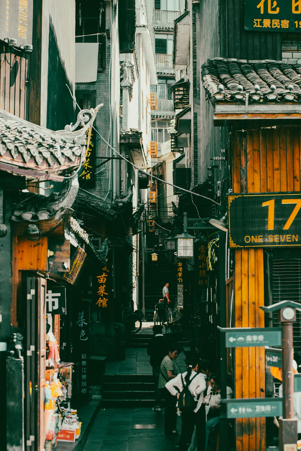 a group of people walking down a street next to tall buildings