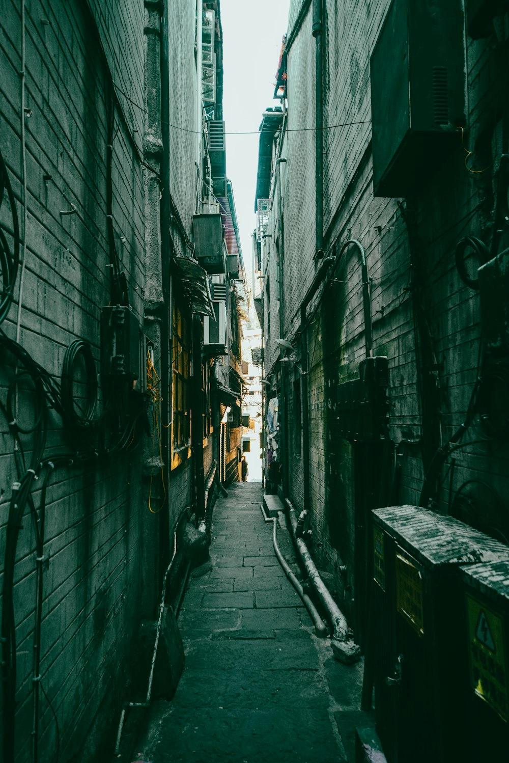 a narrow alley way with a clock on the wall