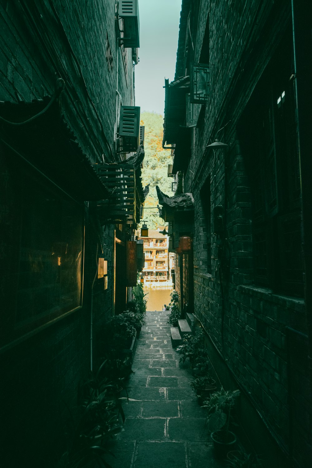 a narrow alley way with a stone building in the background