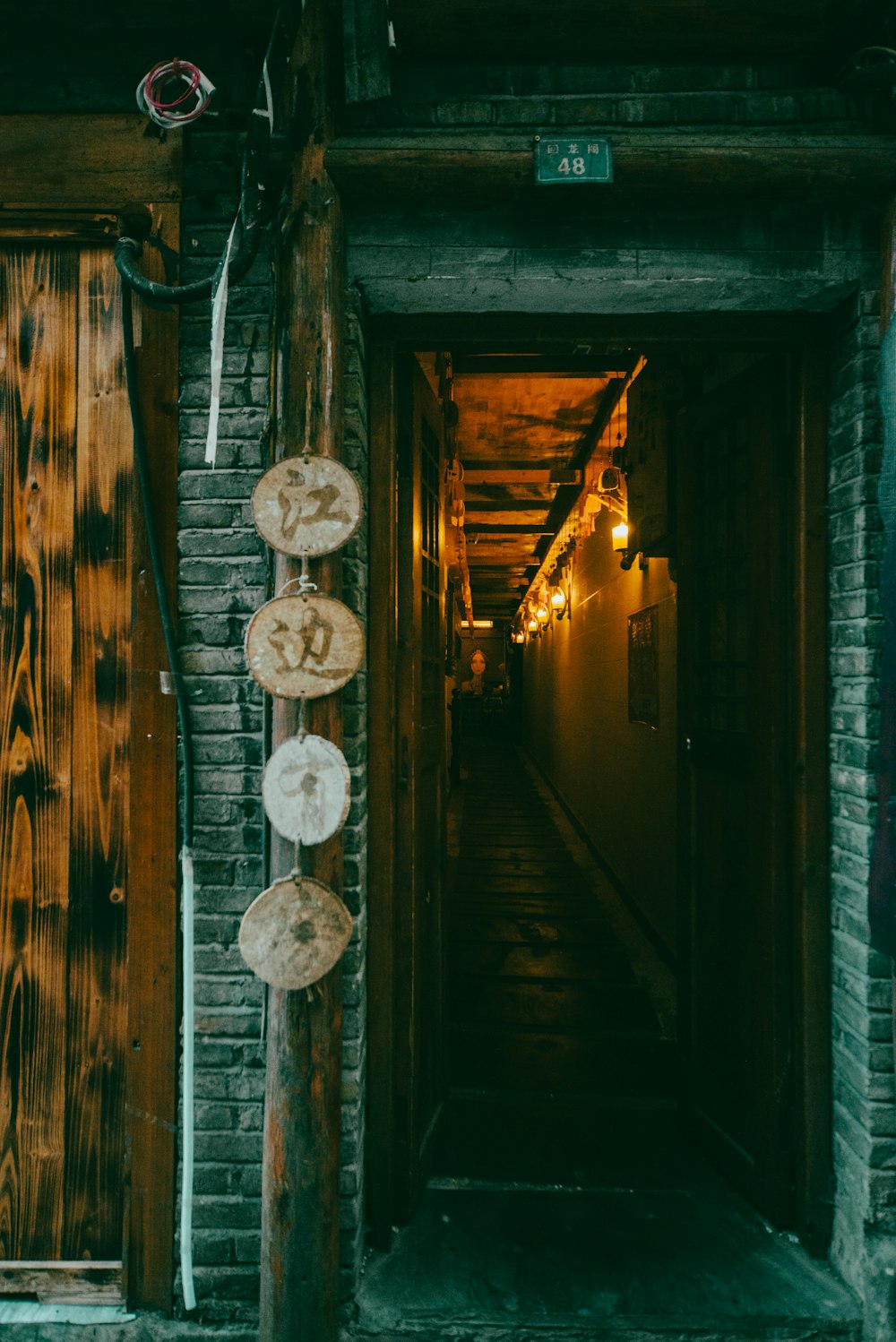 a long hallway with wooden doors leading to another room