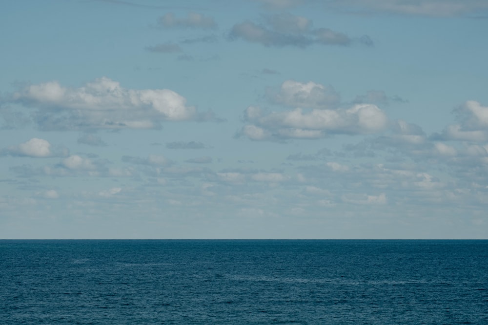 a lone boat floating in the middle of the ocean