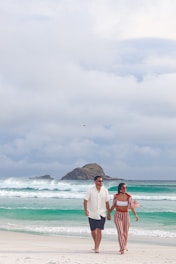 a man and a woman walking on a beach