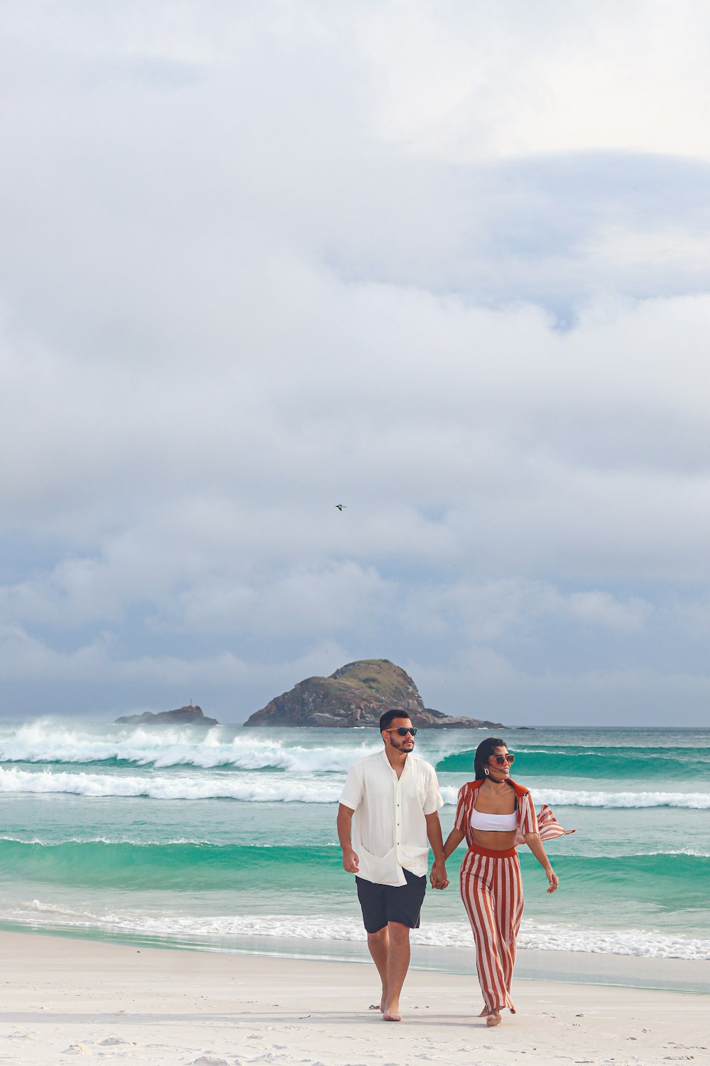 a man and a woman walking on a beach