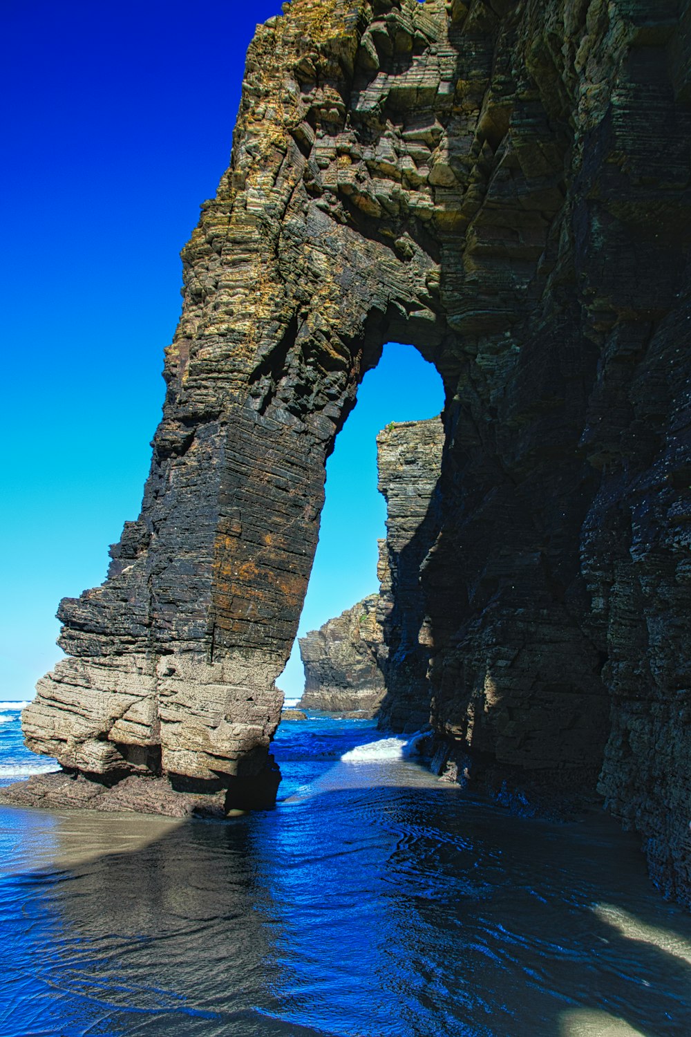 a large rock formation in the middle of a body of water