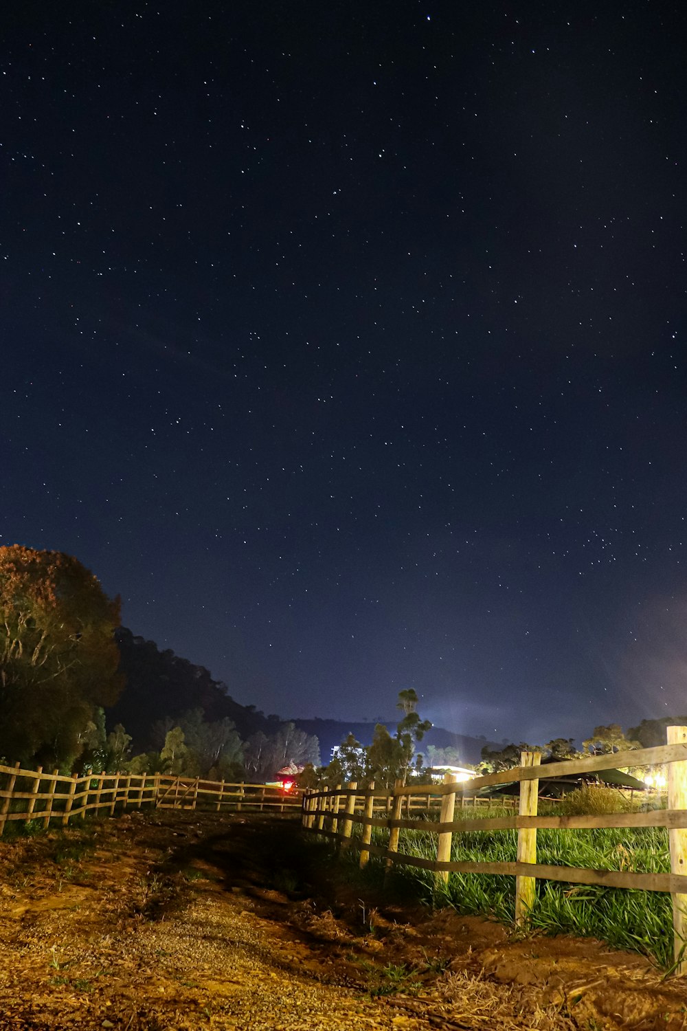 a wooden fence with a night sky in the background