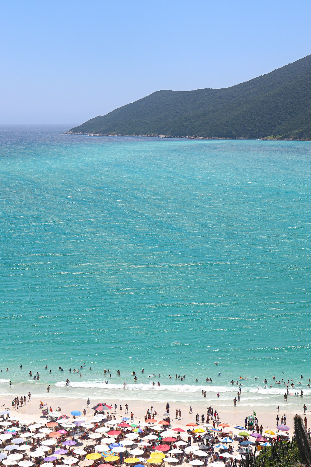 a beach filled with lots of people under umbrellas