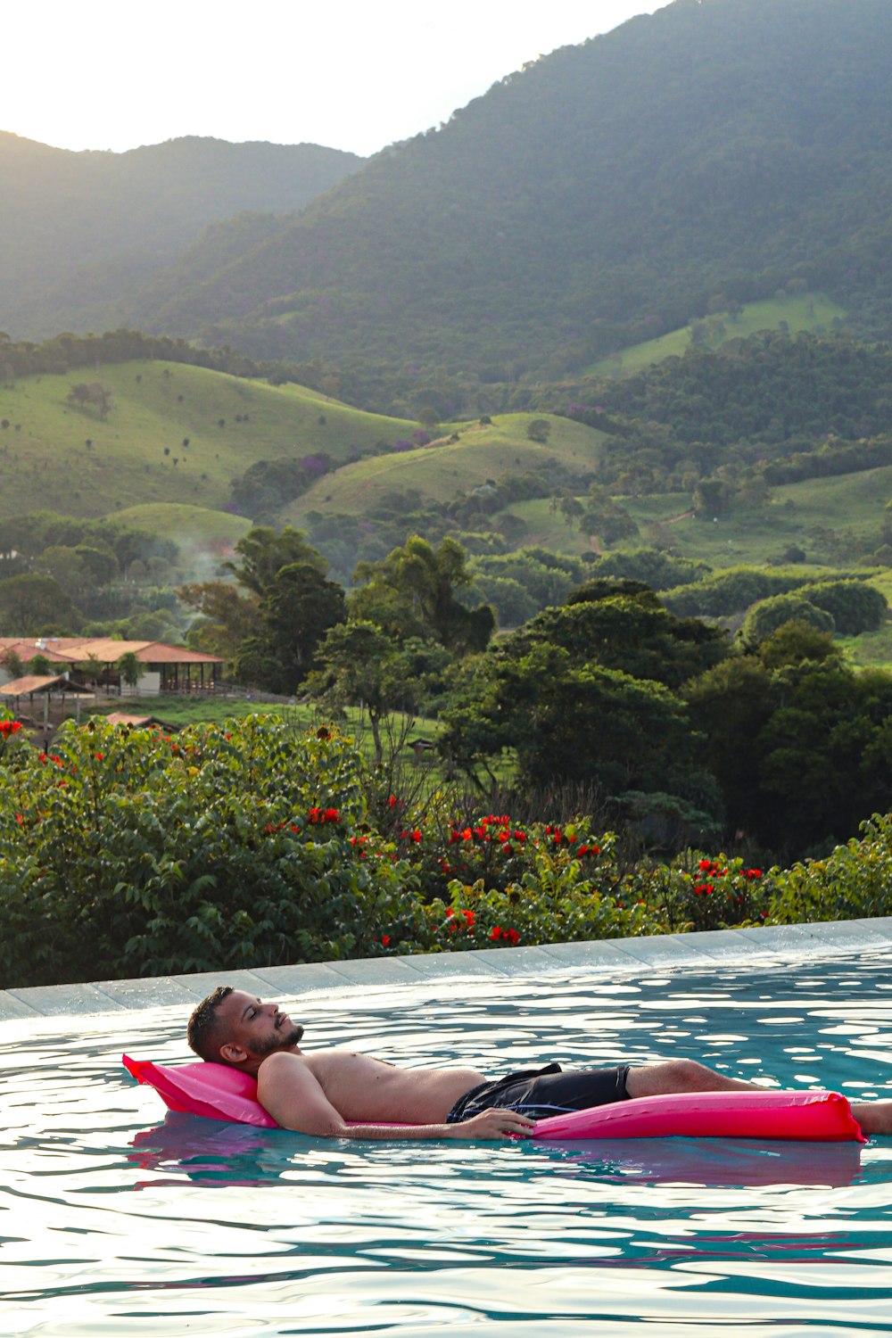 a man laying on a pink floatie in a pool