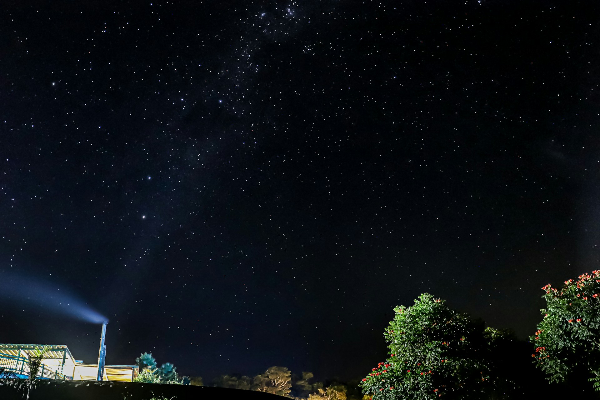 the night sky with stars above a house