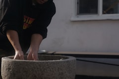a man is placing something in a cement bowl