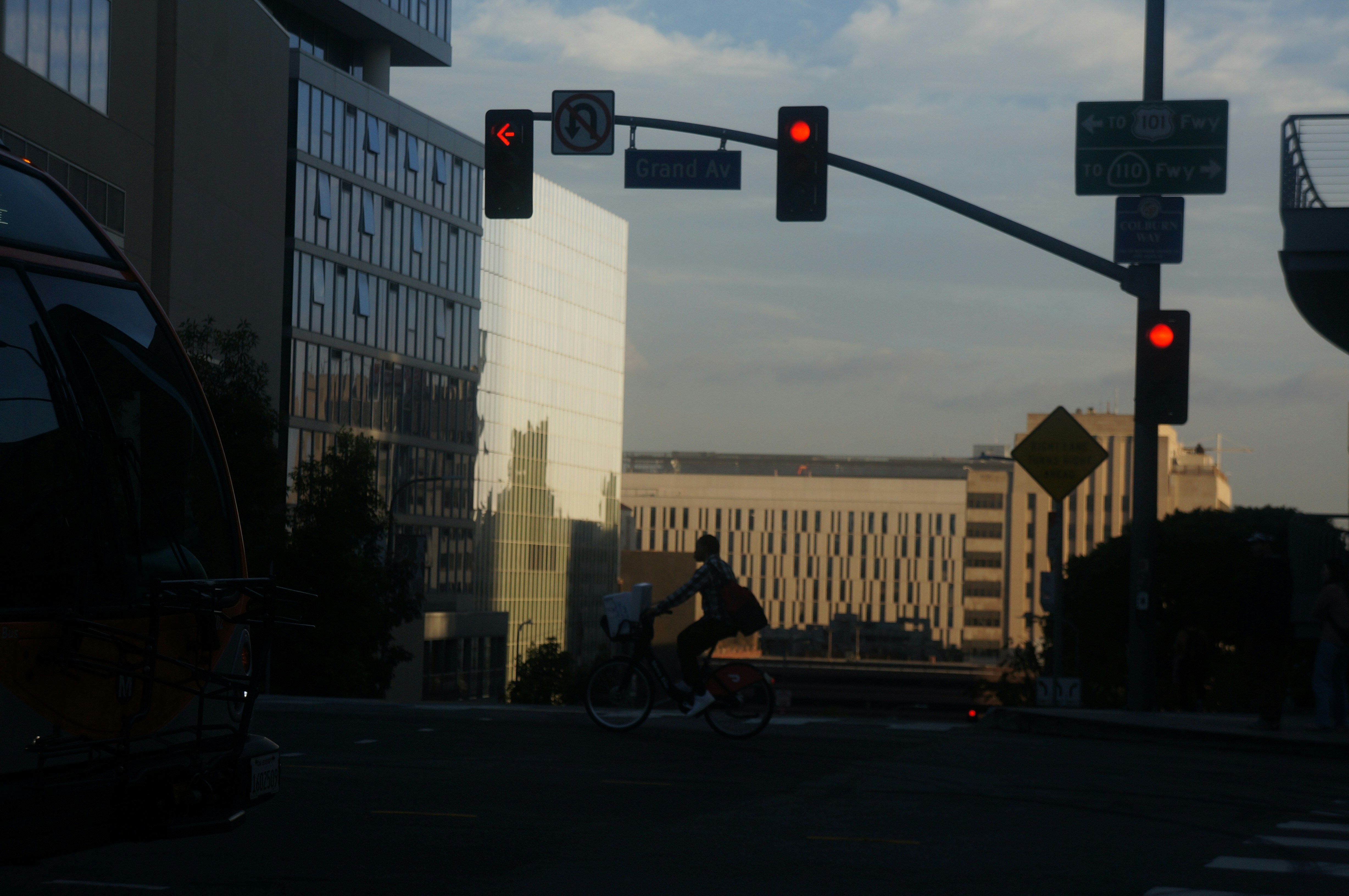 a man riding a bike down a street next to traffic lights