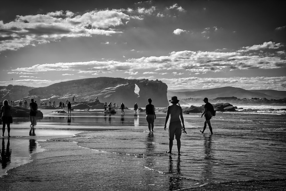 a group of people standing on top of a beach