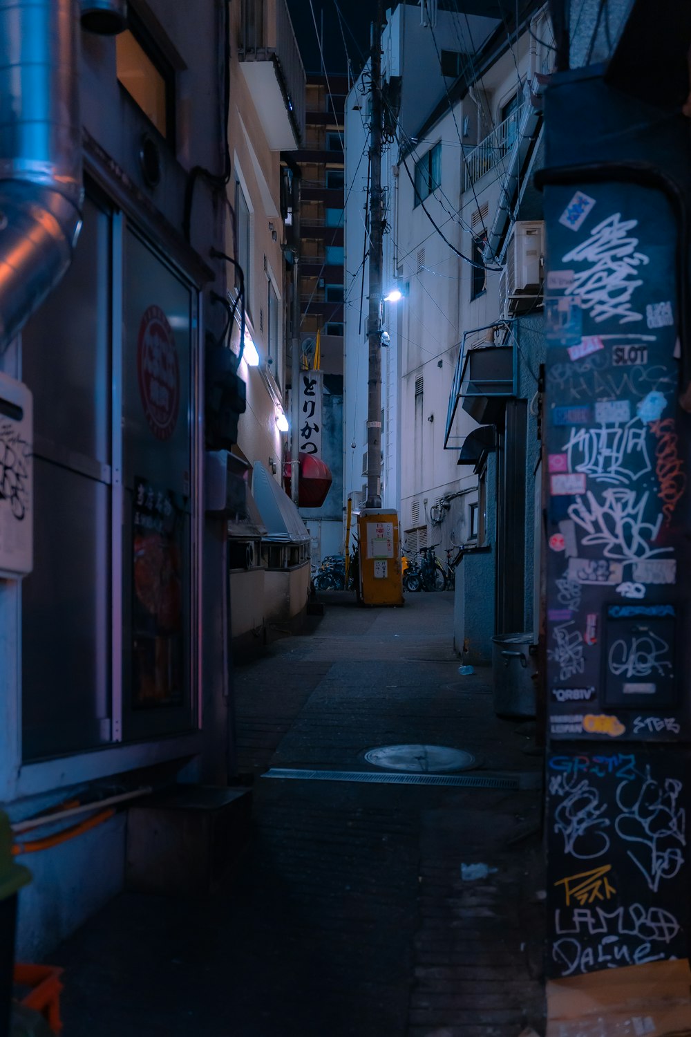 a narrow alley with graffiti on the walls