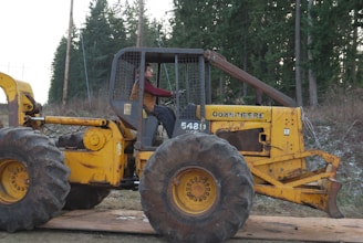 a man sitting on a large yellow tractor
