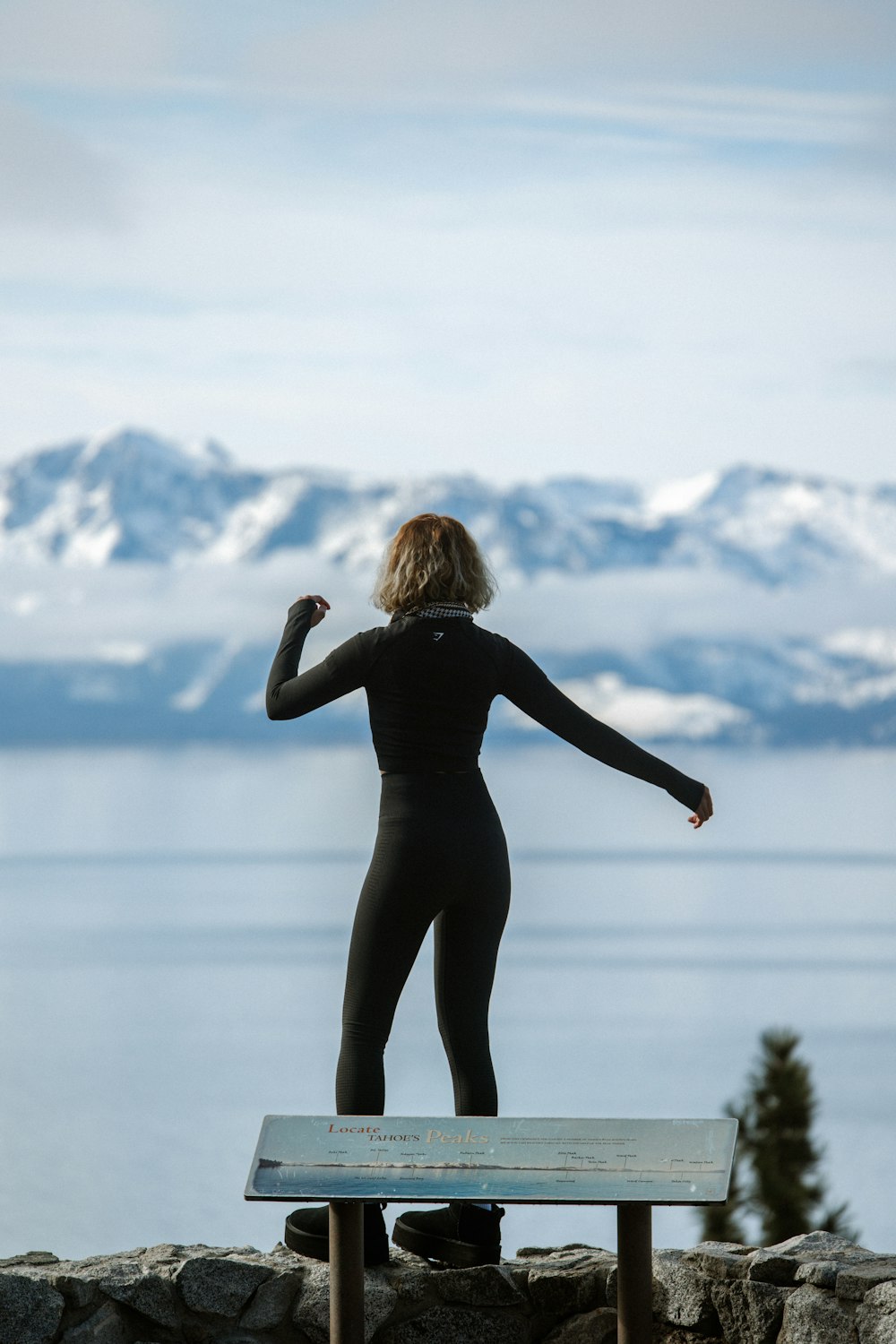 a woman in a wet suit standing on a bench