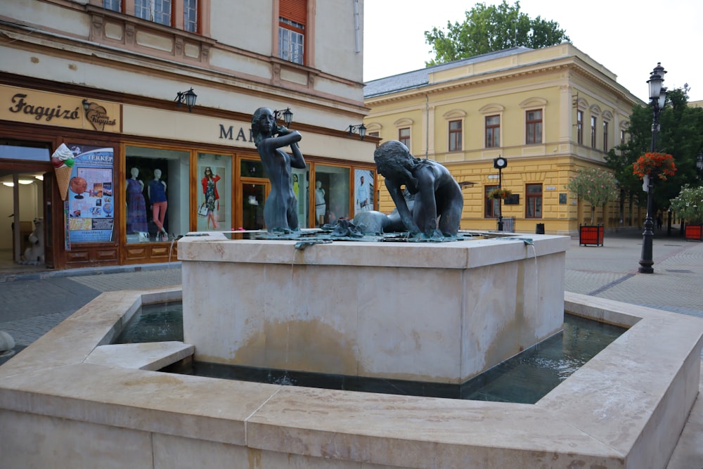 a statue of two people sitting on a fountain