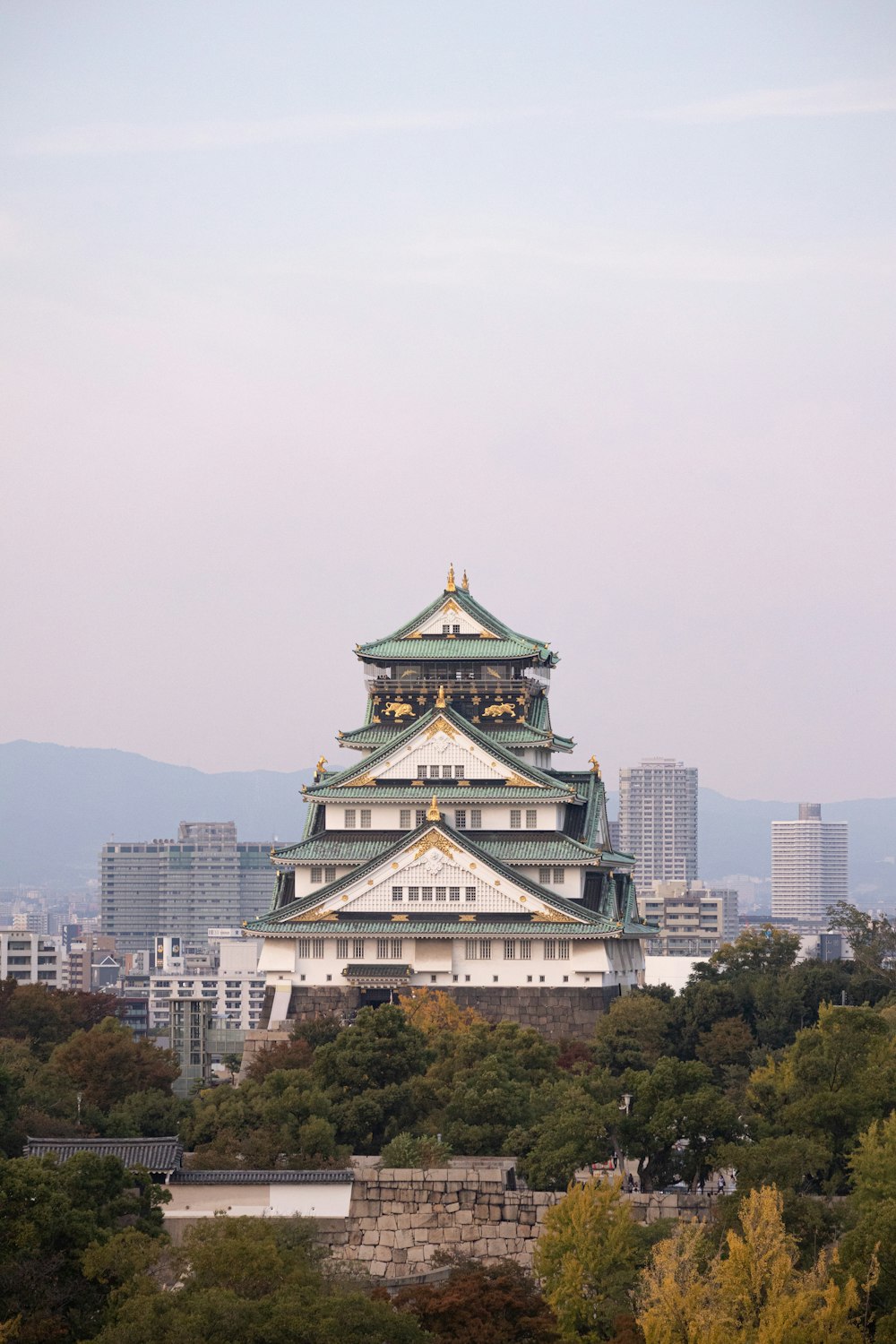 a tall white building with a green roof