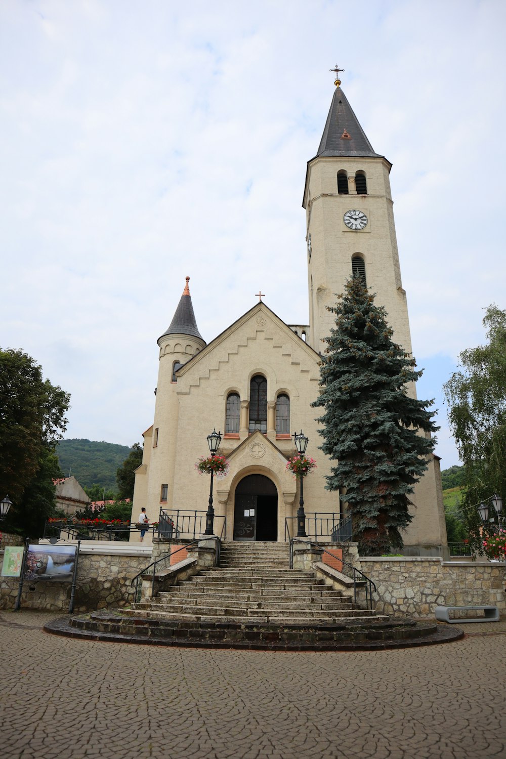 a large church with a clock tower and steps leading up to it