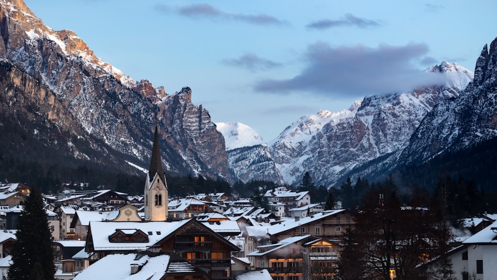 a snowy village with mountains in the background