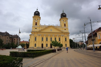a large yellow building with two towers on top of it