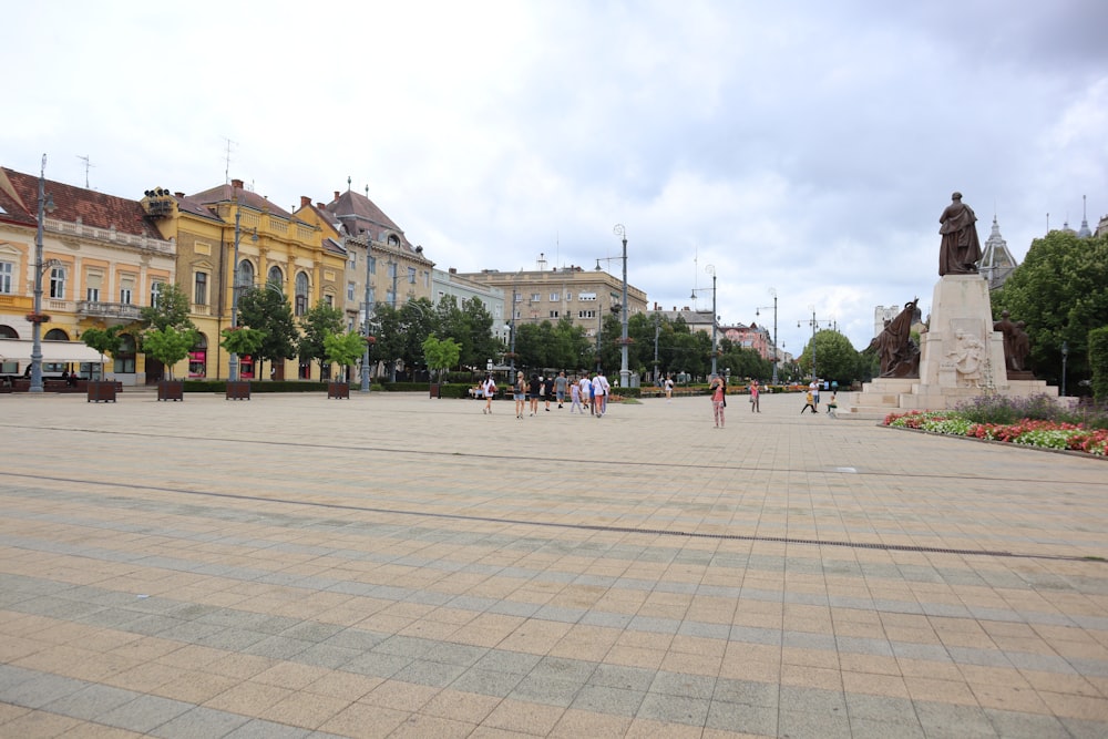 a group of people walking around a plaza in a city