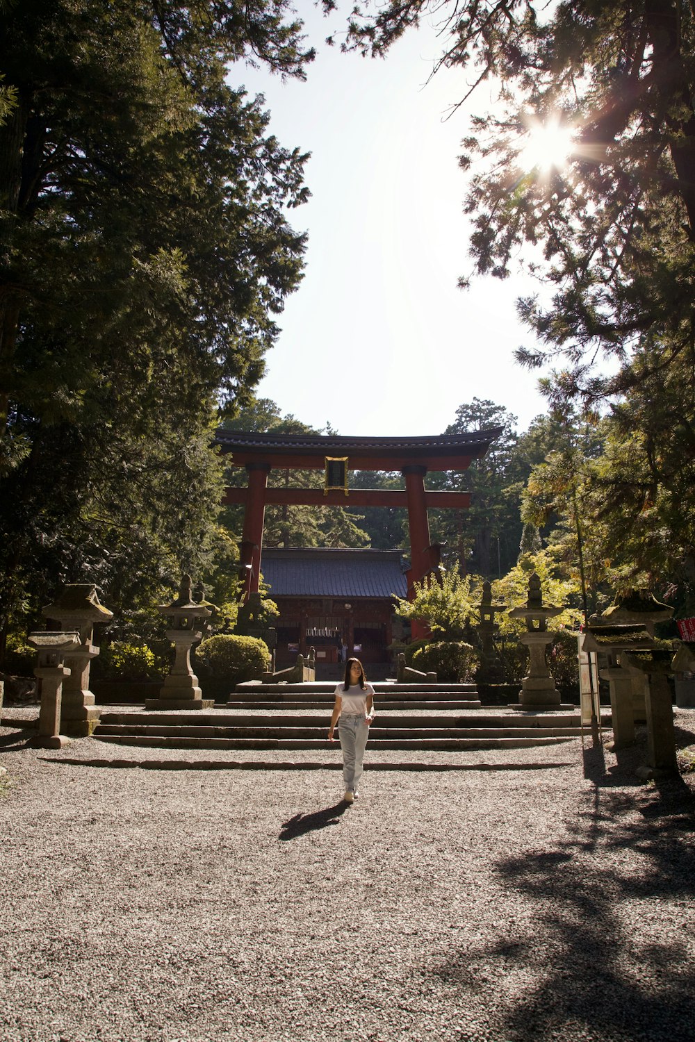 a woman is standing in front of a pagoda