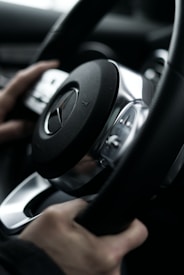 a person driving a car with a steering wheel