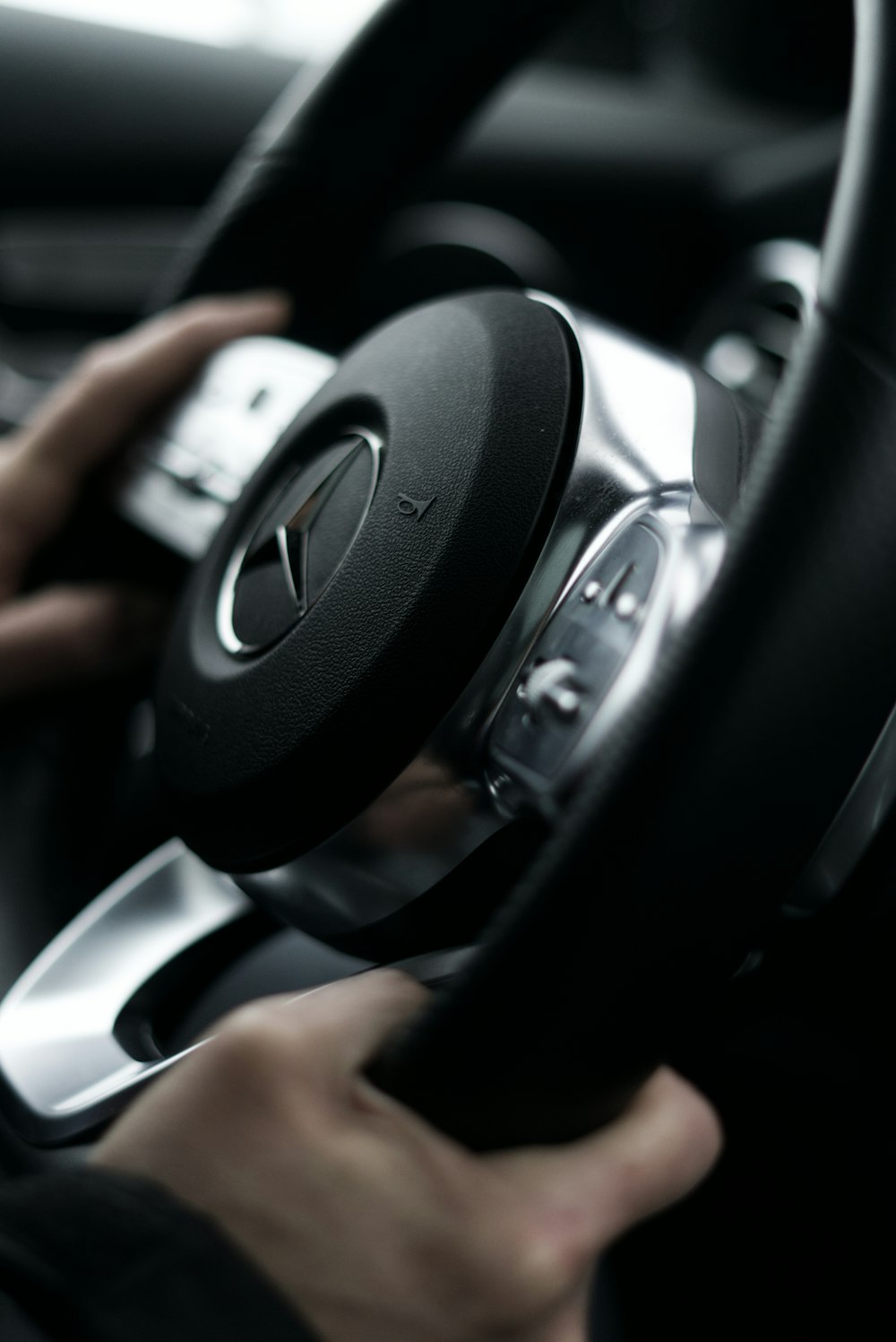 a person driving a car with a steering wheel