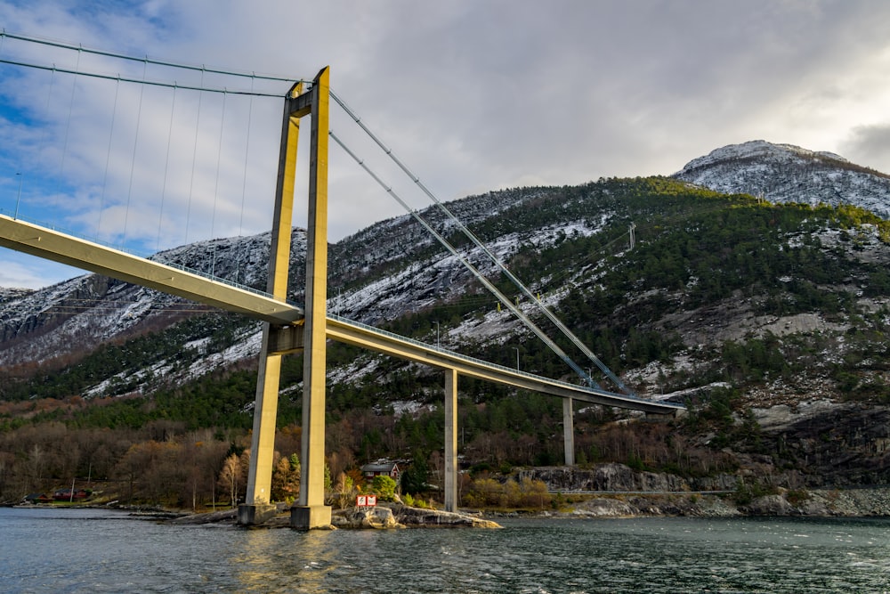 un pont au-dessus d’un plan d’eau avec des montagnes en arrière-plan