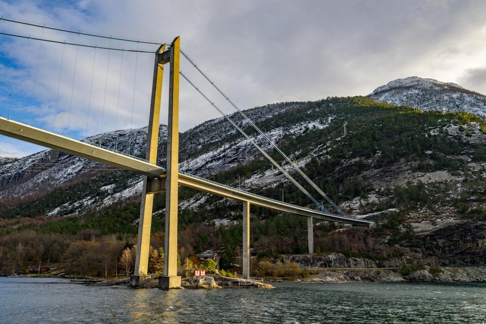 a bridge over a body of water with mountains in the background