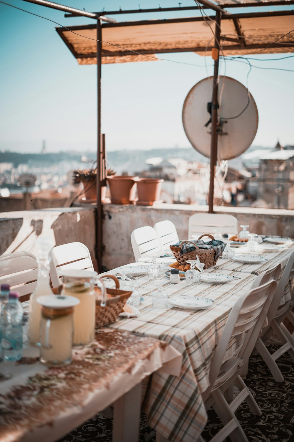 a table set with plates and glasses on top of a roof