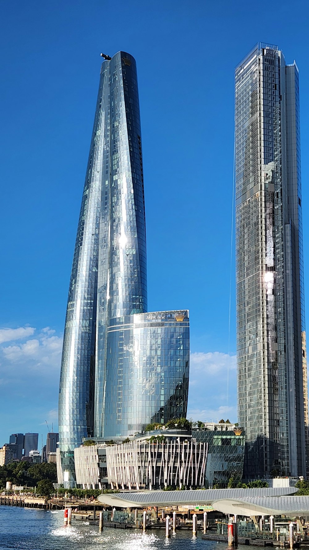 two tall buildings next to a body of water