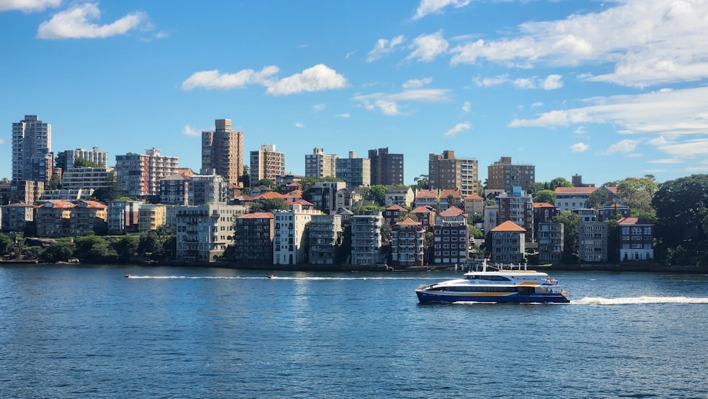 a boat traveling on the water in front of a city