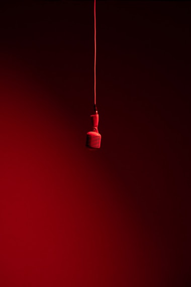 a red light bulb hanging from a red cord