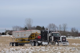 a tractor trailer hauling a large cement truck