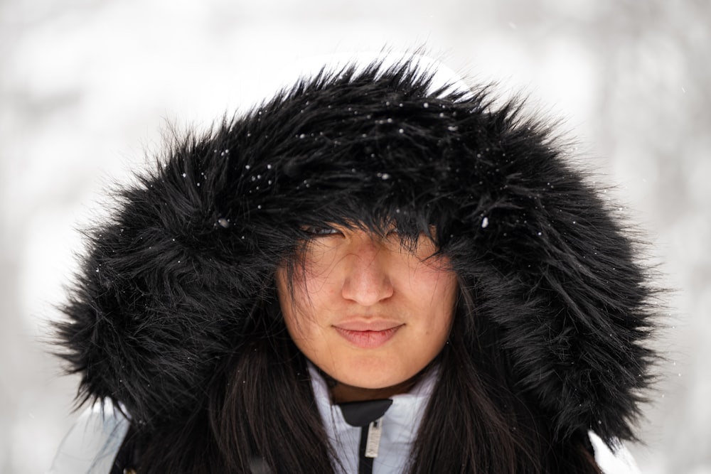 雪の中で毛皮の帽子をかぶった女性