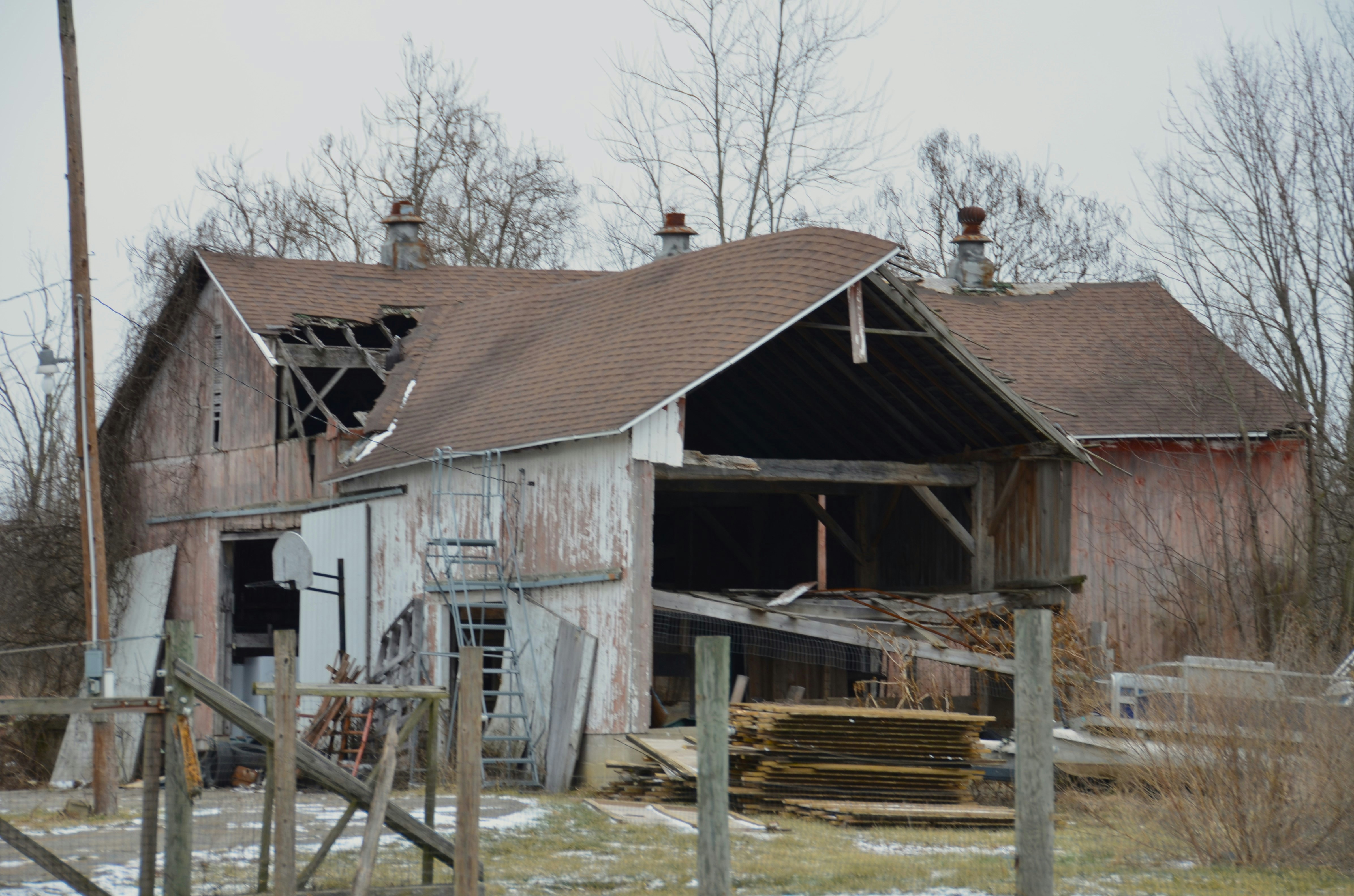 A barn roof with visible rust, leaks, and sagging, illustrating common signs of deterioration - barn roofers near me
