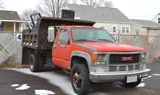 a red dump truck parked on the side of a road
