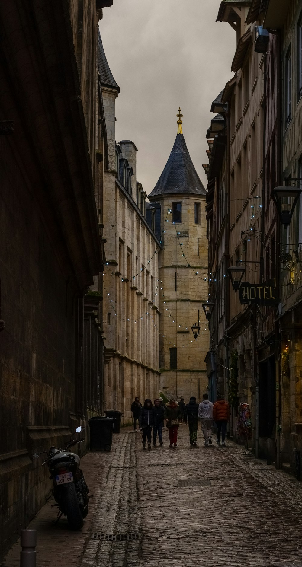 a group of people walking down a cobblestone street