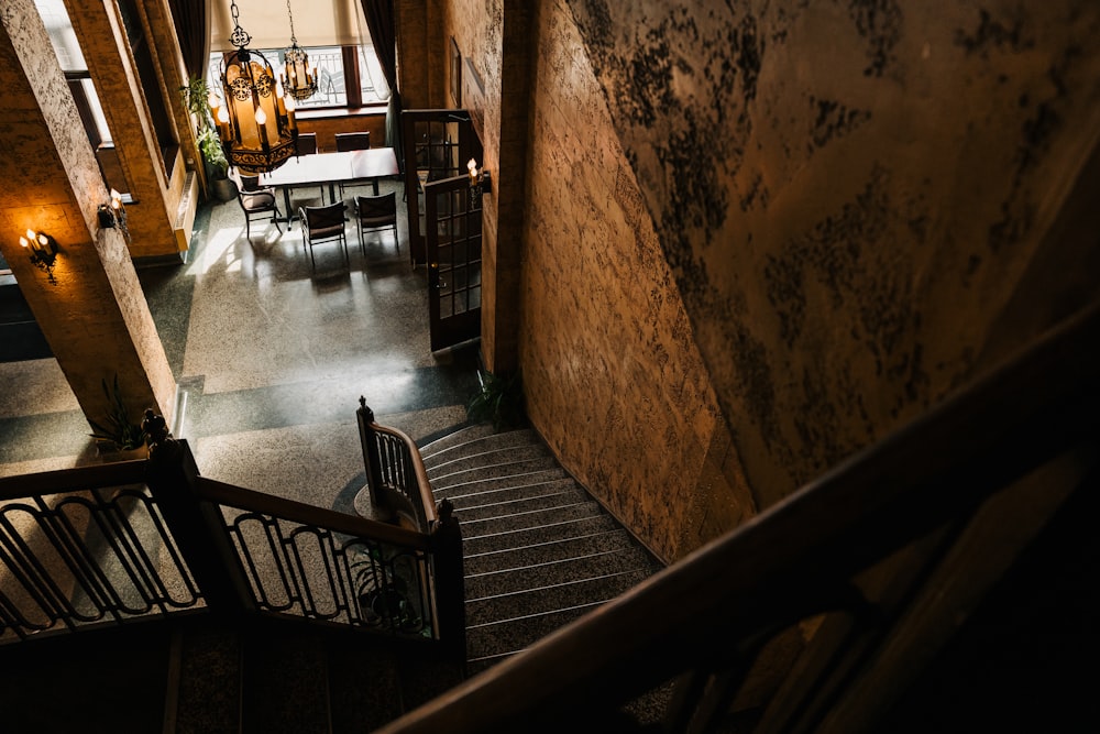 une cage d’escalier menant à une salle à manger avec tables et chaises