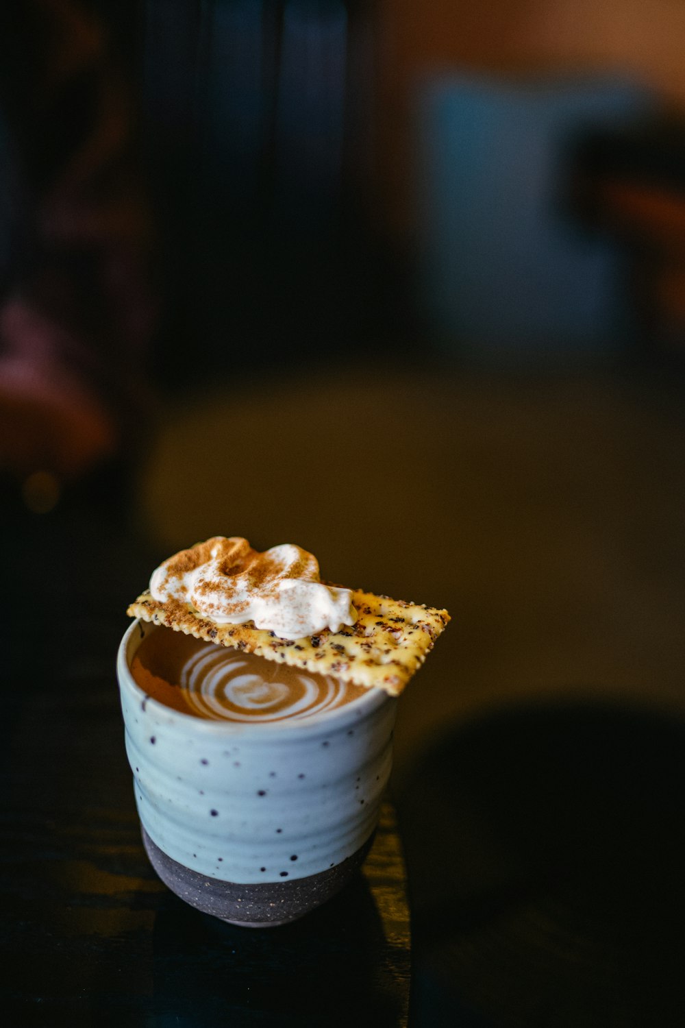 a cup of coffee with a pastry on top of it