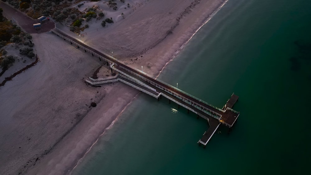 an aerial view of a pier at the beach