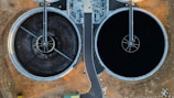 an aerial view of two large black tanks