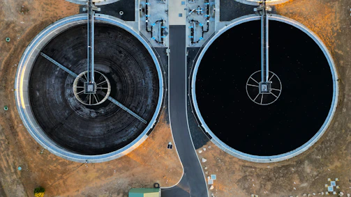 an aerial view of two large black tanks